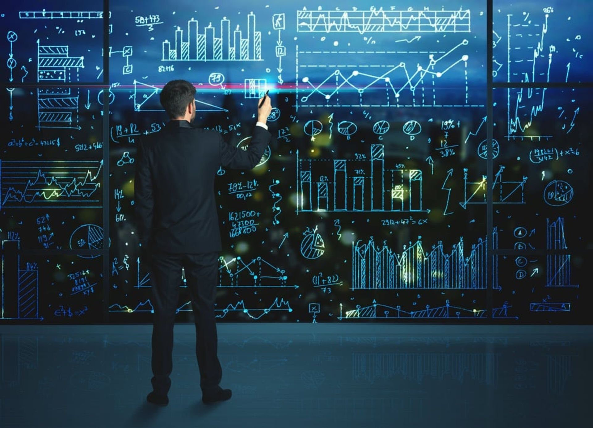 Businessman drawing business statistics on glass wall.jpeg